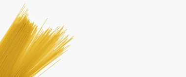 Beyaz arka planda çiğ, uzun bir spagetti. Üst manzara, düz yatış. Pankart