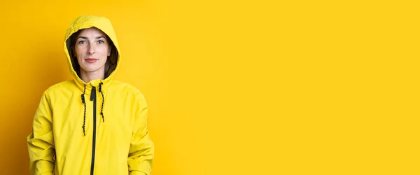Mujer Joven Con Una Chaqueta Con Capucha Amarilla Sobre Fondo — Foto de Stock