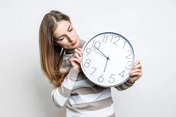 Mujer Joven Mira Pared Reloj Blanco Sus Manos Sobre Fondo — Foto de Stock