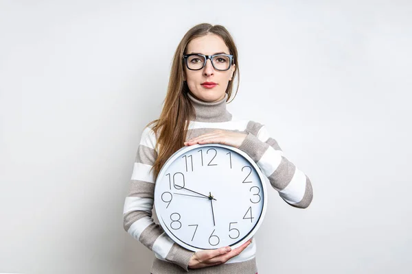 Mujer Joven Con Gafas Sosteniendo Reloj Pared Sobre Fondo Claro — Foto de Stock