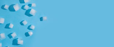 Mavi arka planda bir sürü buz küpü var. Üst manzara, düz yatış. Pankart.