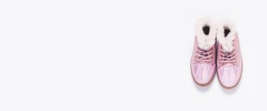 Beyaz arka planda pembe çocuk ayakkabıları. Üst manzara, düz yatış. Pankart