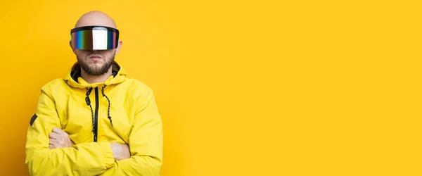 Young man in cyberpunk glasses in a yellow jacket on a yellow background. Banner.