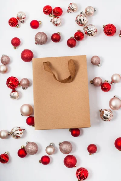 Craft gift bag, decorative balls on a white background. Top view, flat lay