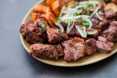 Et kebabı ızgara domuz eti, sığır eti ve bir restoranda soğanlı bir tabakta tavuk.