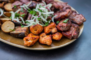 Etli ızgara domuz eti, sığır eti ve soğanlı bir tabakta tavuk.