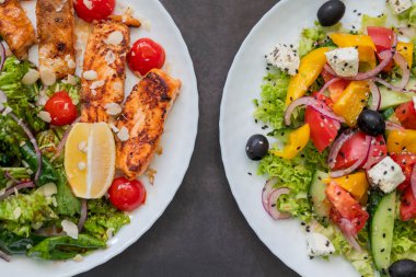 Zeytinli, peynirli ve kızarmış somonlu iki Yunan salatası.