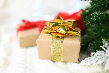 Noel ağacının yanında yeni yıl ve sevgililer günü için altın bir fiyonklu güzel bir sürpriz hediye kutusu.