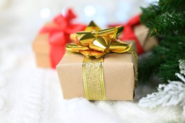 Noel ağacının yanında yeni yıl ve sevgililer günü için altın bir fiyonklu güzel bir sürpriz hediye kutusu.