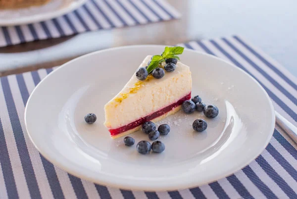Bir tabak yaban mersinli tatlı cheesecake. Nane yaprağıyla bir restoranda.