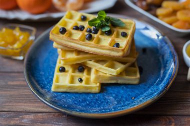 Belgian waffles for breakfast with honey and currants