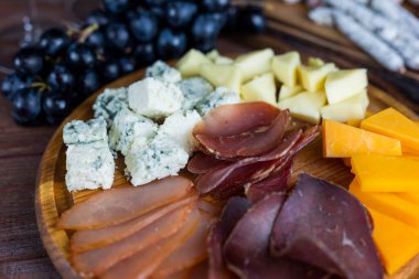 Ahşap bir tahtada üzümlü mozzarella soslu mavi peynir.