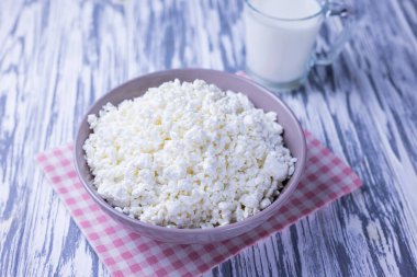 Süt ürünü süzme peynir ve bir bardak süt. Ahşap arka planda.