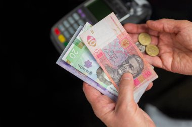 Yaşı ilerlemiş yaşlı bir adam Ukrayna 'nın Hryvnia emekli maaşını elinde tutuyor.