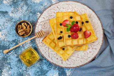 Tatlı Belçika waffleları, çilek ve ballı yaban mersini.