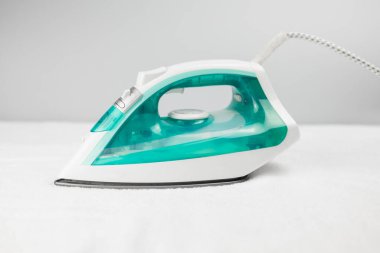 Çarşaf ütülemek ve turkuaz kıyafetler için ütü.