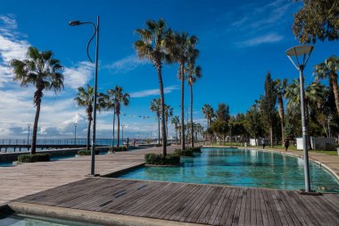 gezinti güvertesi Limasol güzel. Cyu 'da palmiye ağaçları ve deniz kıyısında yüzme havuzları var.