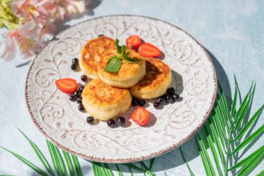 Kahvaltıda peynirli kek ve bir restoranda böğürtlen.