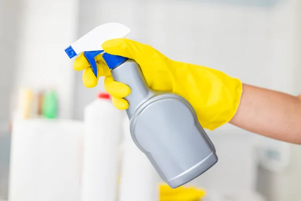 girl hotel worker in rubber gloves with cleaning products does cleaning in the bathroom with a means for cleanliness and disinfection