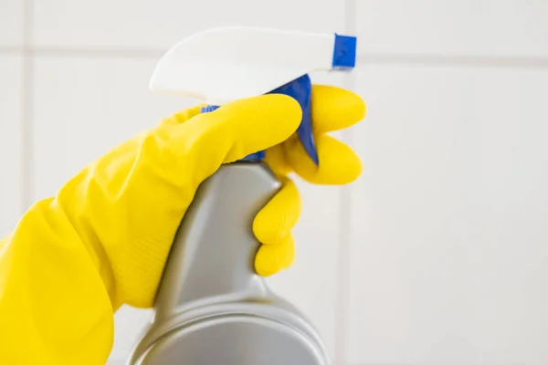 girl hotel worker in rubber gloves with cleaning products does cleaning in the bathroom with a means for cleanliness and disinfection