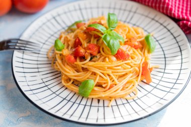 Italian pasta in a restaurant with tomato sauce and basil