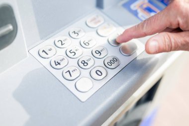Bir kadın kredi kartından para çekmek için ATM 'ye şifreli giriş yapıyor.