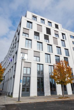 Pencereleri ve terasları olan güzel, modern bir bina tasarımı.