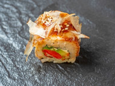 Siyah bir tabakta suşi rulosunun yakın çekimi. Geleneksel Japon mutfağı. Üst manzara, düz uzanma