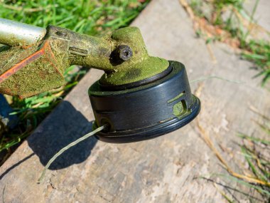 Naylon bir olta ipiyle benzin budayıcısının başına yakın çekim.