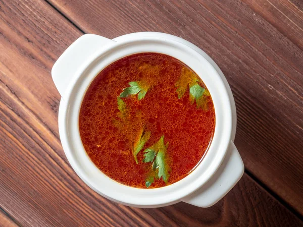 将罗宋汤放在木制背景的白色陶瓷汤碗中进行特写 俄罗斯和乌克兰的传统汤 绿色漂浮在汤的顶部 — 图库照片