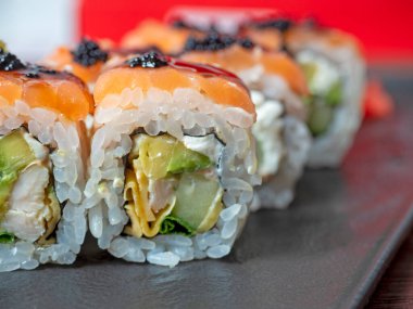 Siyah bir tabakta suşi rulosunun yakın çekimi. Geleneksel Japon mutfağı