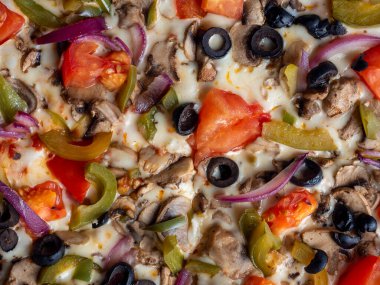 Sebzeli ve mantarlı lezzetli vejetaryen pizzanın yakın çekimi. Yemek arkaplanı. Üst görünüm, seçici odaklanma. Sağlıksız yiyecekler