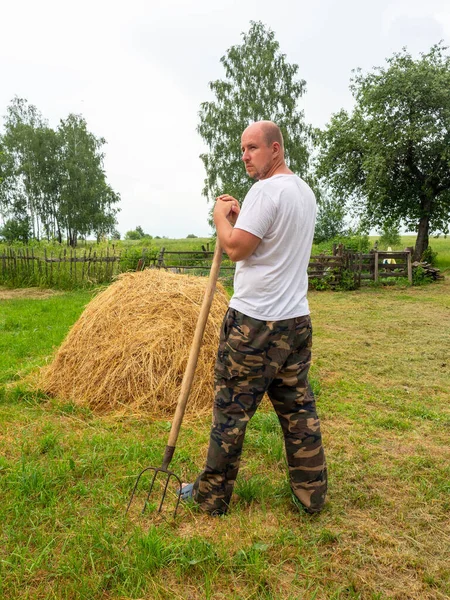 Man Stands His Back Camera Pitchfork Front Haystack Rural Landscape Stock Image