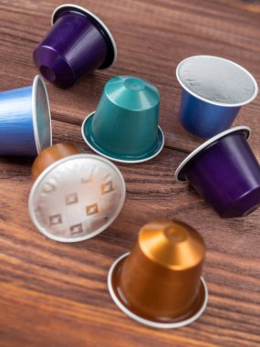 10.03.2021 Rusya, Moskova. Kahverengi ahşap zemin üzerinde Nespresso kahvesi olan parlak renkli kapsüller. Yaklaş, kenar görünüm