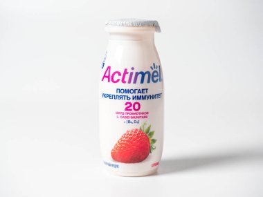 20.10.2021, Moskova, Rusya. Aktif Mel 'in beyaz arka planda plastik bir şişede çilek aromalı yoğurt içişini yakından çek. İzole bir nesne, Rusya için bir ürün. Ön görünüm