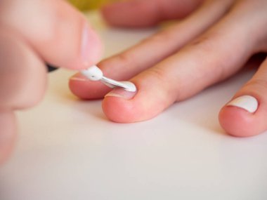 Tırnağa beyaz oje sürüyorum. Manikür ve tırnak bakımı kavramı