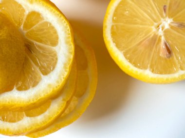 Beyaz arka planda dilimlere ayrılmış bir limonu yakından çek. İzole meyve. Vitamin dolu ekşi sarı meyve. Üst görünüm