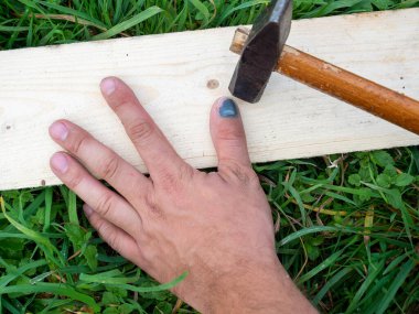 Bir işçinin yakın çekimi ıskalar ve elinin başparmağına vurur. Hematom, çürük, çürük. Çimenler iş başında. Sigorta şirketi. Üst manzara, düz uzanma