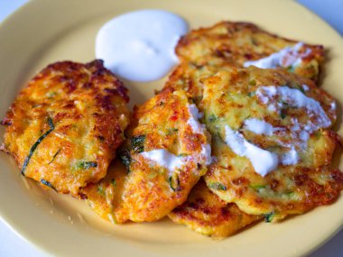 Kabak ve sebzeli krep tabağa konmuş ve ekşi kremayla servis edilmiş. Üst manzara, düz uzanma