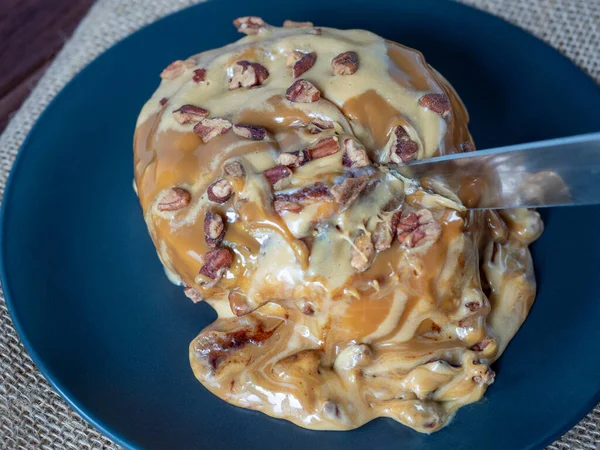 Close Cinnamon Bun Drizzled Caramel Decorated Nuts Lies Black Plate — Stock Photo, Image