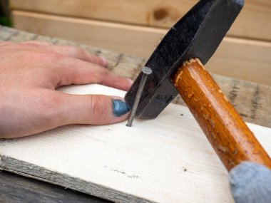 Bir işçinin yakın çekimi ıskalar ve elinin başparmağına vurur. Hematom, çürük, çürük. Çimenler iş başında. sigorta.