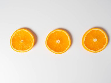 Beyaz arka planda üç dilim olgun portakalın yakın plan görüntüsü. Vitamin dolu nefis meyveler. Stüdyo çekimi, üst görünüm