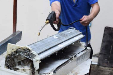 Klima temizleme konsepti. İşçi, havalandırmayı temizleyen kirli bir makine. Profesyonel Temizlik servisi ve bakımı ile klima temizleme, filtreleri tamir ve temizleme.