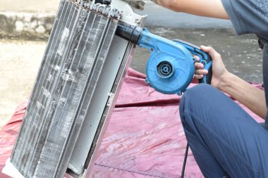 Klima temizleme konsepti. Havalandırmayı tamir eden bir işçi. Profesyonel Temizlik servisi ve bakımı ile klima temizleme, filtreleri tamir ve temizleme.