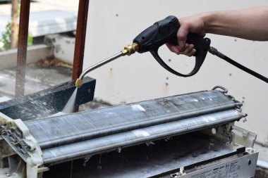 Klima temizleme konsepti. İşçi, havalandırmayı temizleyen kirli bir makine. Profesyonel Temizlik servisi ve bakımı ile klima temizleme, filtreleri tamir ve temizleme.