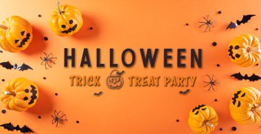 Balkabağı, kağıt yarasalar ve turuncu arka planda siyah örümcekten yapılmış Cadılar Bayramı süslemeleri..