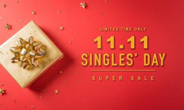 Çin 'de online alışveriş, 11.11 bekarlar günü konsepti. Kırmızı arka planda kurdeleli altın noel hediye kutularının en üst görüntüsü