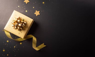 Kara Cuma yılbaşı hediye kutusunun en üst görüntüsü ve koyu arkaplanda kurdele. Alışveriş konsepti boks günü ve Kara Cuma kompozisyonu.