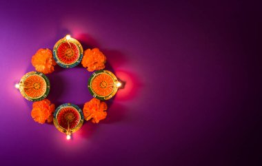 Mutlu Diwaliler - Dipavali sırasında Clay Diya lambaları yandı, Hindu ışık festivali kutlaması. Mor arka planda renkli geleneksel gaz lambası diya
