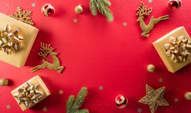 Noel ve yeni yıl konsepti. Noel hediye kutusunun en üst görüntüsü, ren geyikleri, Noel balosu ve kırmızı arka planda kar tanesi.